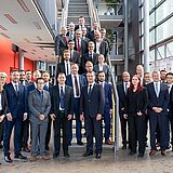 Eine Gruppe von Menschen steht auf einer Treppe und daneben